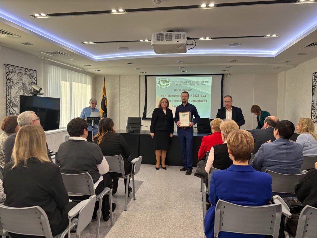 Фото 8. Вручение участнику награды по итогам проведения мероприятий Дня молодого избирателя в 2024 году
