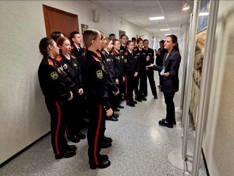 Фото 1. Участники Дня открытых дверей в территориальной избирательной комиссии, проведенного в рамках Дня молодого избирателя ознакамливаются с выставочной экспозицией Администрации города Сургута. Стоят перед стендами экспозиции и слушают рассказ лектора. 