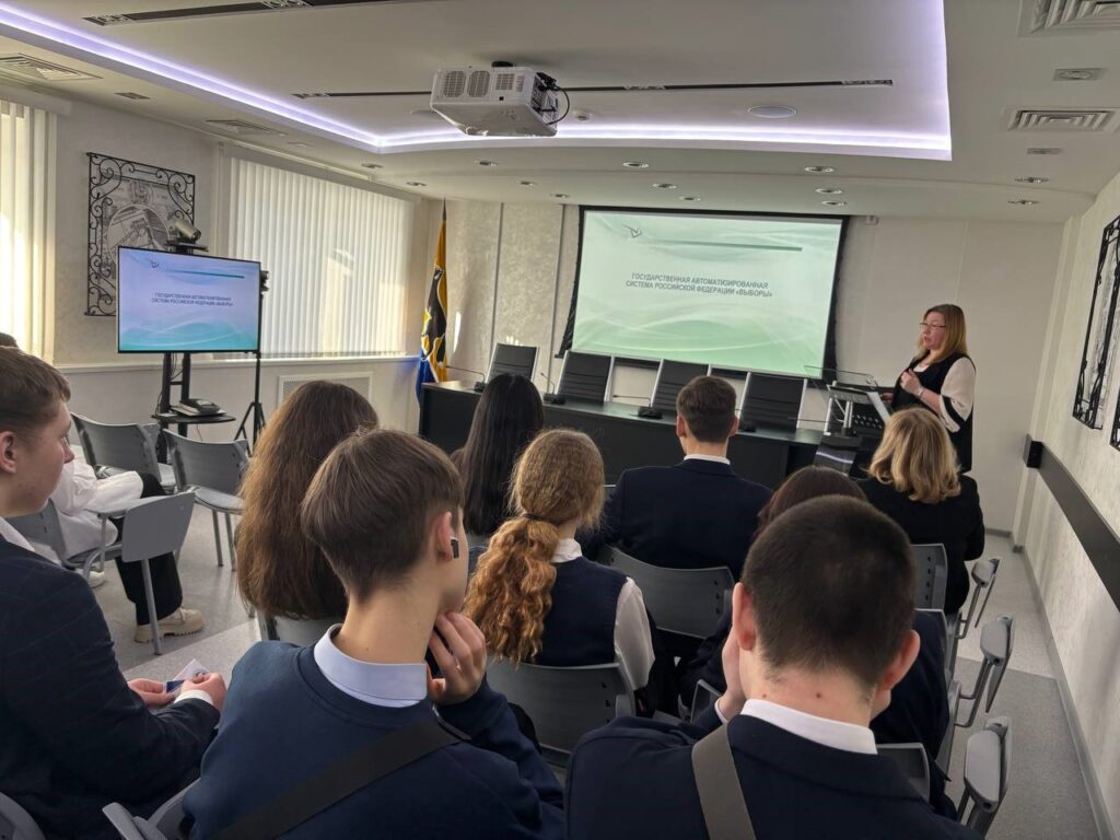 Фото 7. Участники Дня открытых дверей в территориальной избирательной комиссии, проведенного в рамках Дня молодого избирателя слушают лекцию  системного администратора  ТИК  Г.В. Трусовой  о голосовании с использованием механизма «Мобильный избиратель», ознакамливаются с работой комплексов обработки избирательных бюллетеней КОИБ-2010.